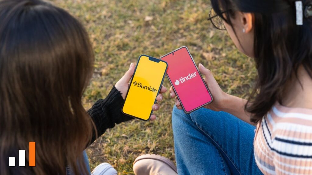 Duas pessoas segurando celulares com os apps Bumble e Tinder abertos