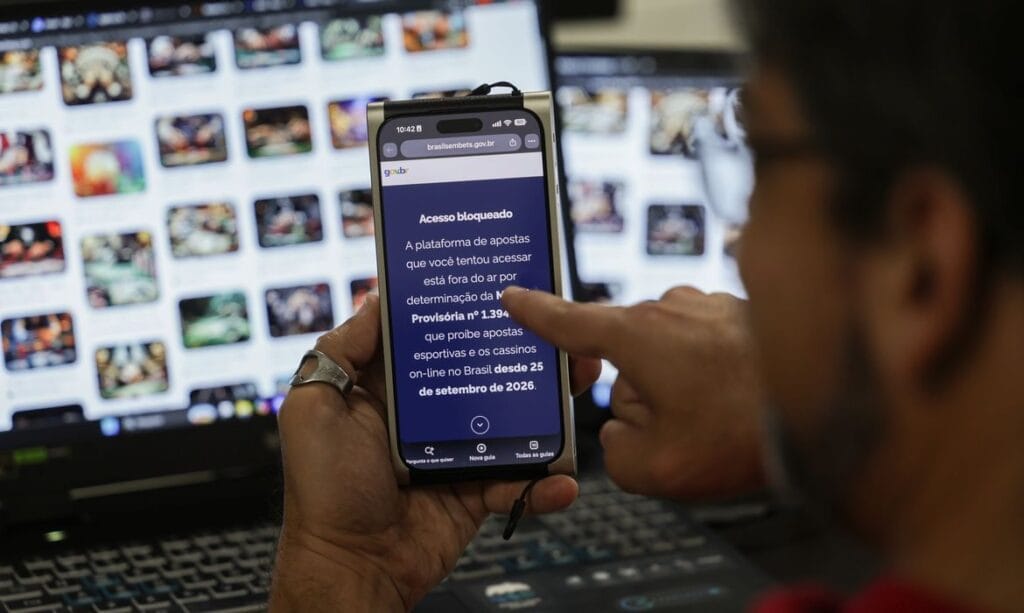 Celular exibe a página do governo que avisa o bloqueio de uma plataforma de apostas por causa da MP 1.394/2026, em Brasília, em 06/10/2026