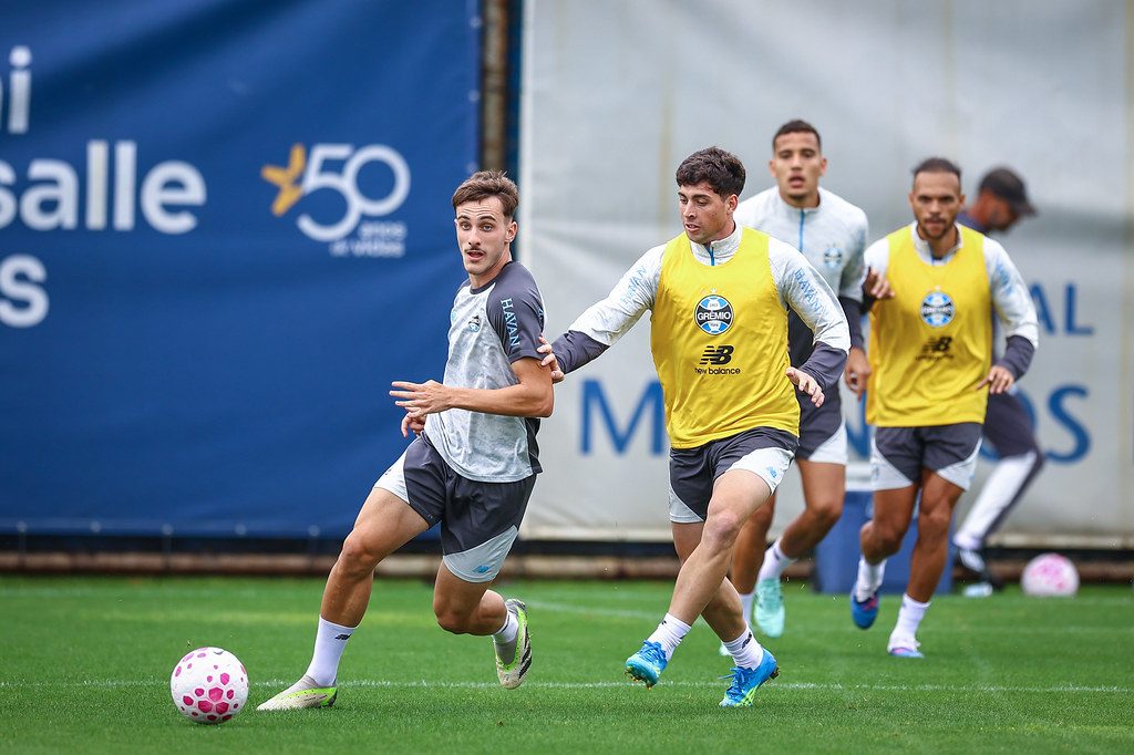 Jogadores do Grêmio, alguns de colete amarelo, disputam a bola em treino no CT Luiz Carvalho